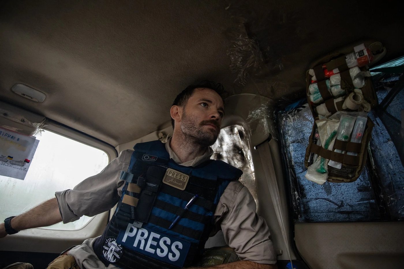 Campbell MacDiarmid wearing a PRESS vest inside a vehicle